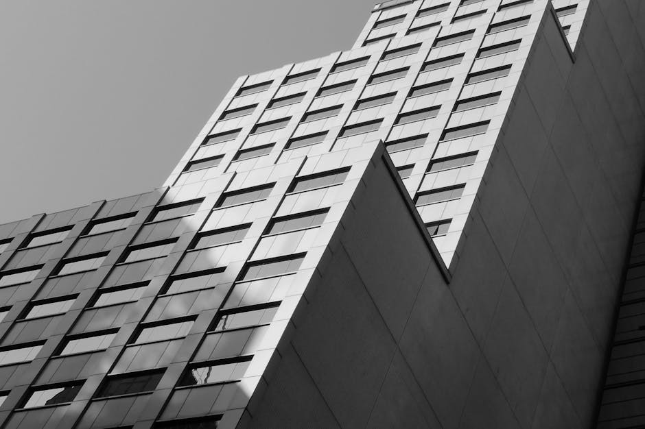 Low angle view of a modern high-rise building with glass windows in Hong Kong, in black and white.