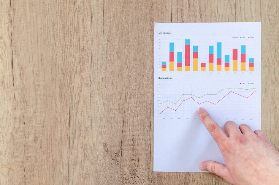 pexels-photo-590041-590041-1 Hand analyzing business graphs on a wooden desk, focusing on data results and growth analysis.